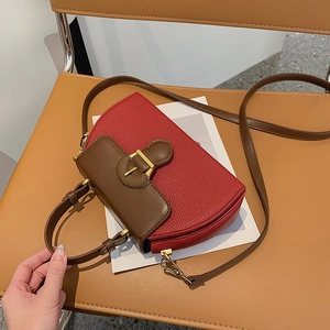 Detail der rot-braunen Satteltasche mit goldener Vintage-Schnalle und Kieselleder-Optik