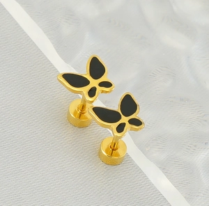 Détail macro de boucles d'oreilles papillon en or 18 carats avec émail noir et fermoir à vis