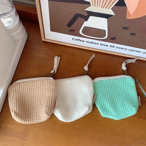 Vue détaillée de petits sacs de rangement à texture gaufrée en brun, blanc et vert menthe