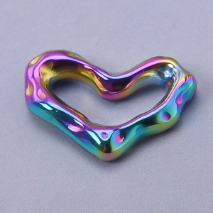 Macro detail of rainbow colored hollow heart pendant in 304 stainless steel texture