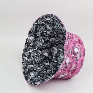 Double-sided bucket hat featuring black and white skull patterns and floral print