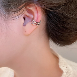 Close-up of silver-tone ear cuff featuring a delicate purple gemstone on the ear