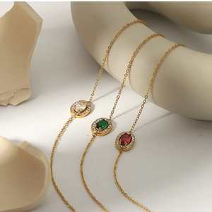 Detail of gold titanium steel bracelets with oval emerald, ruby, and zircon gemstones