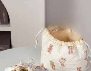 Quilted makeup bag with teddy bear pattern and cream drawstring closure for travel