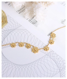 Detail of gold daisy flower anklet with metallic luster on white decorative background