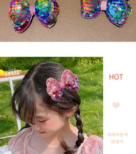 Detail of girls glitter bow hair clip with colorful laser sequins on outdoor model