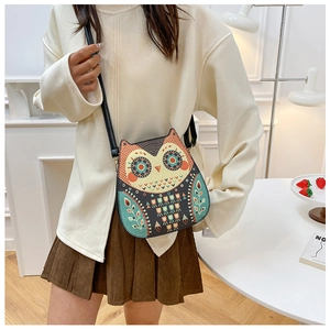 Sac à bandoulière en forme de hibou de style ethnique porté par un mannequin de mode
