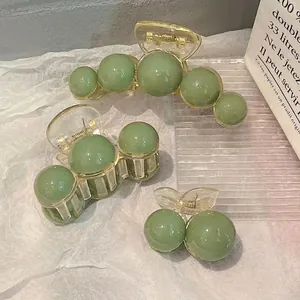 Three-piece set of transparent green pearl hair claws in various sizes for women
