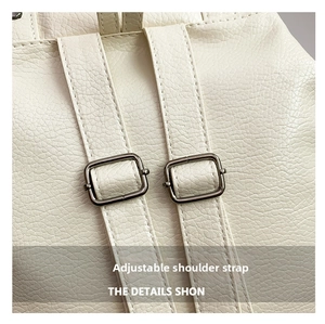 Detail of adjustable straps on cream textured backpack with silver metal buckles