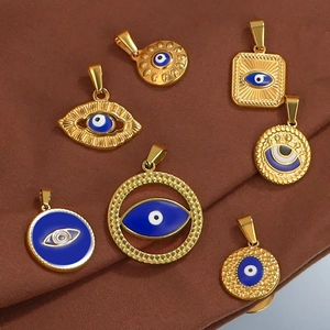 Collection of golden evil eye pendants with blue enamel detail on dark fabric