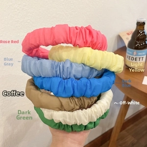 Detail of seven colorful pleated fabric headbands including blue, yellow, and rose red colors