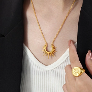 Golden sunburst pendant necklace and vintage signet ring set on female model
