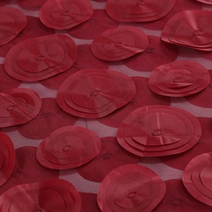 Close-up of 3D red floral embroidery on mesh fabric for a formal evening gown