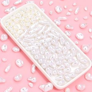 Irregular white ABS imitation pearls in various shapes displayed on a tray for DIY jewelry