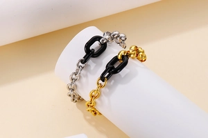 Détail de bracelets en acier titane et résine aux finitions dorées, argentées et noires