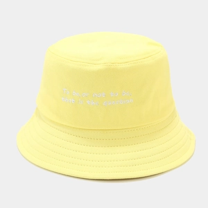 Detailed view of white literary embroidery on a bright yellow cotton bucket hat