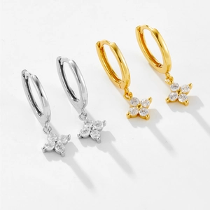 Detail of S925 silver hoop earrings with four-leaf flower pendants in gold and silver