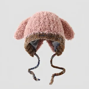 Detalle de gorro de invierno rosa de felpa con orejas de perro y lazos trenzados