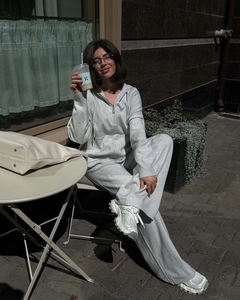 Dettaglio del set felpa con cappuccio e zip e pantaloni larghi in maglia grigia