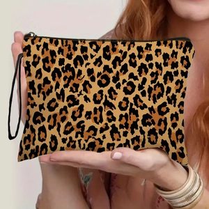 Chic leopard print makeup bag with black wrist strap held by a model for travel storage