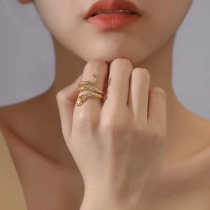 Macro shot of gold-plated snake ring featuring detailed scale texture and black eyes