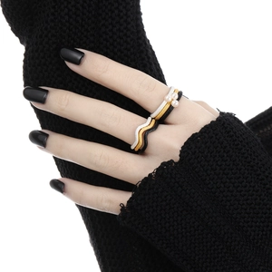 Three-piece wave-shaped rings set in gold, silver, and black with white pearls