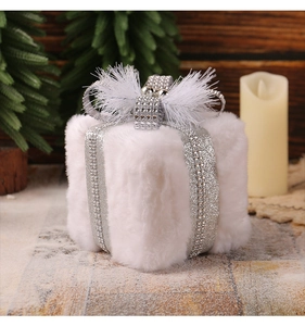 Detail of plush white Christmas gift box ornament with silver glitter ribbon and bow