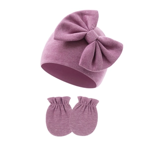 Detail showing knit texture of newborn baby bow hat and matching scratch mittens