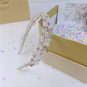 Detailed close-up of double-layered crystal headband with floral beads on gift box