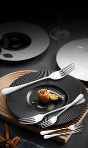Polished stainless steel dining fork series arranged elegantly on a ceramic dinner plate