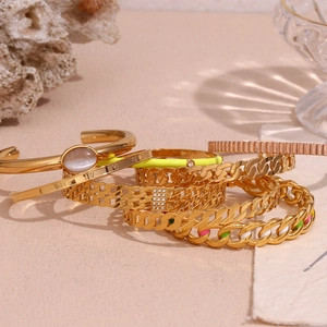 Detail of 18K gold-plated bracelets featuring Roman numerals and neon enamel accents