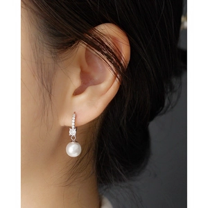 Elegant long pearl drop earrings with sparkling crystals and silver metal on a model