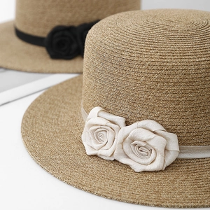 Elegant straw boater hat with silk flowers and ribbon for sun protection at the beach