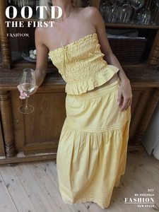 Detail of light yellow smocked tube top with tiered maxi skirt and ruffled texture