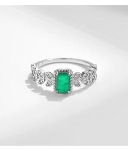 Detailed macro of S925 sterling silver ring with emerald-cut green stone and leaf design