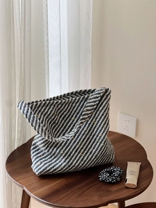 Dettaglio di una borsa tote intrecciata a righe bianche e nere minimalista con puntini colorati
