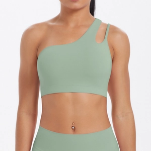 Detail of light green one-shoulder sports bra with cutout strap and brushed nylon texture
