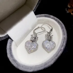 Sparkling zircon heart earrings with crown detail displayed in a plush velvet jewelry box