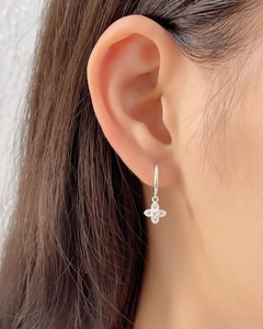 Close-up of S925 sterling silver four-leaf clover earring with crystals on model's ear