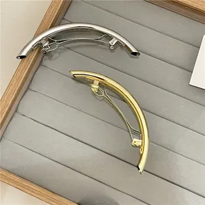 Polished minimalist gold and silver spring hair clips on a velvet tray detail