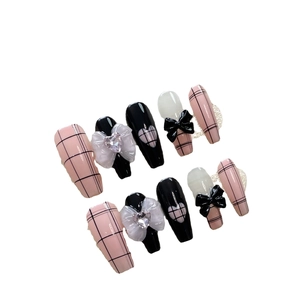 Set de uñas postizas hechas a mano con diseño de cuadros rosa y negro y lazos 3D