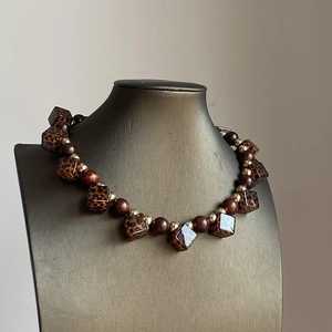 Retro acrylic leopard square and wooden bead necklace on a jewelry display bust
