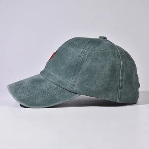 Dettaglio del cappellino da baseball in tela lavata grigio-verde con logo a fragola