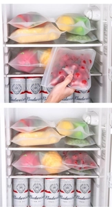 Reusable frosted silicone food storage bags organized in a refrigerator setting