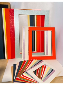 Assorted colorful frame mats for children's artwork in various textures and sizes