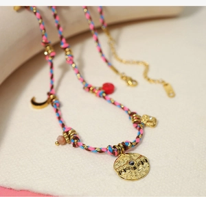Macro shot of bohemian colorful woven choker with gold pendants and coin charms
