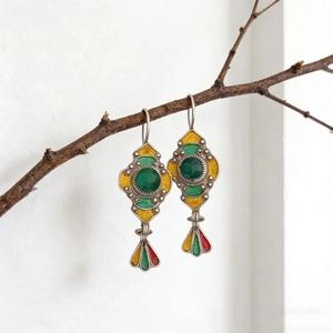 Détail de boucles d'oreilles vintage géométriques avec émail coloré sur une branche