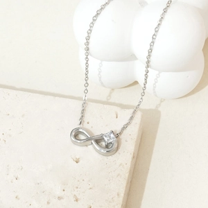 Macro detail of silver infinity pendant necklace with a square clear zircon setting