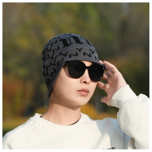 Detail of grey men's winter knitted hat with black jacquard pattern and small brim