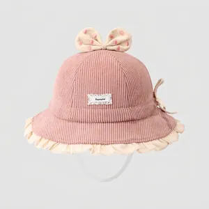 Detailansicht eines rosa Baby-Fischerhuts aus Cord mit gepunkteter Schleife und Rüschen